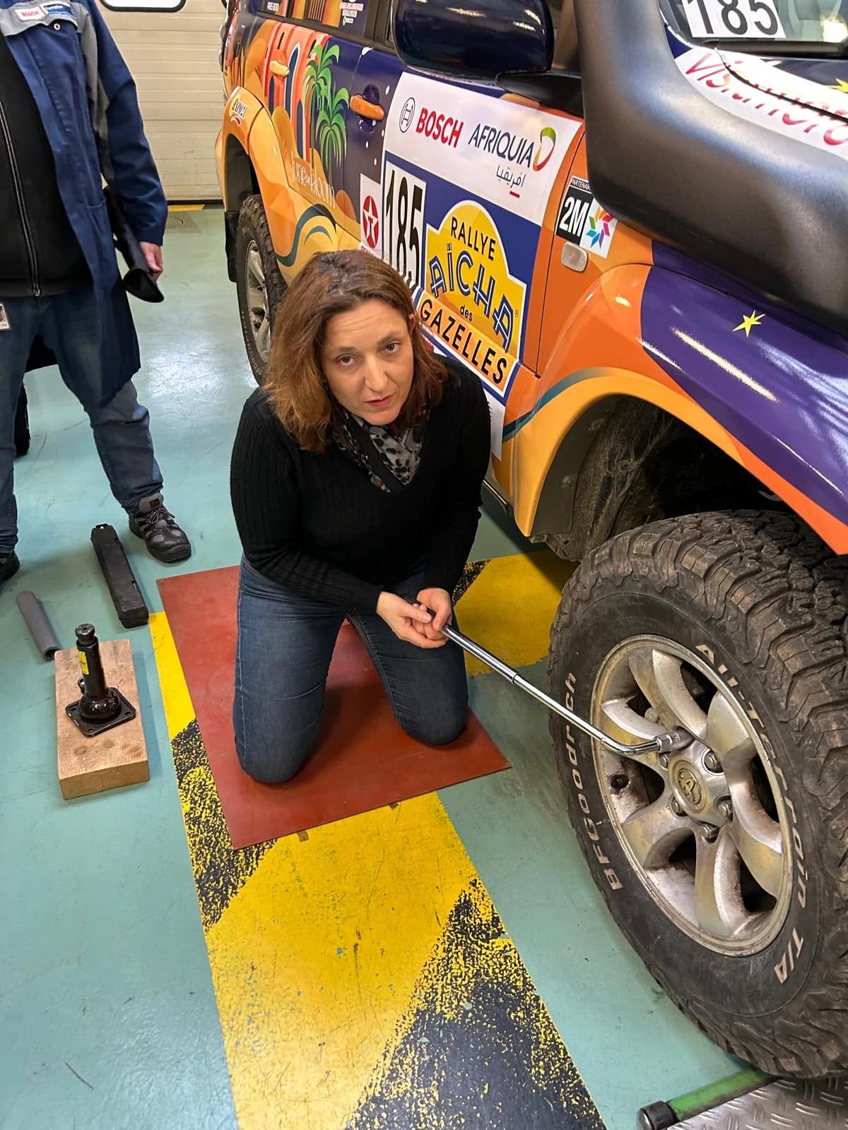 Marina vérifiant l'état d'un pneu après une étape