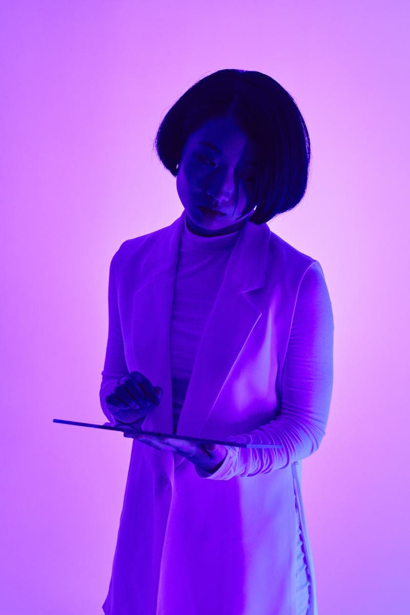 Silhouette utilisant une tablette devant un fond lumineux coloré